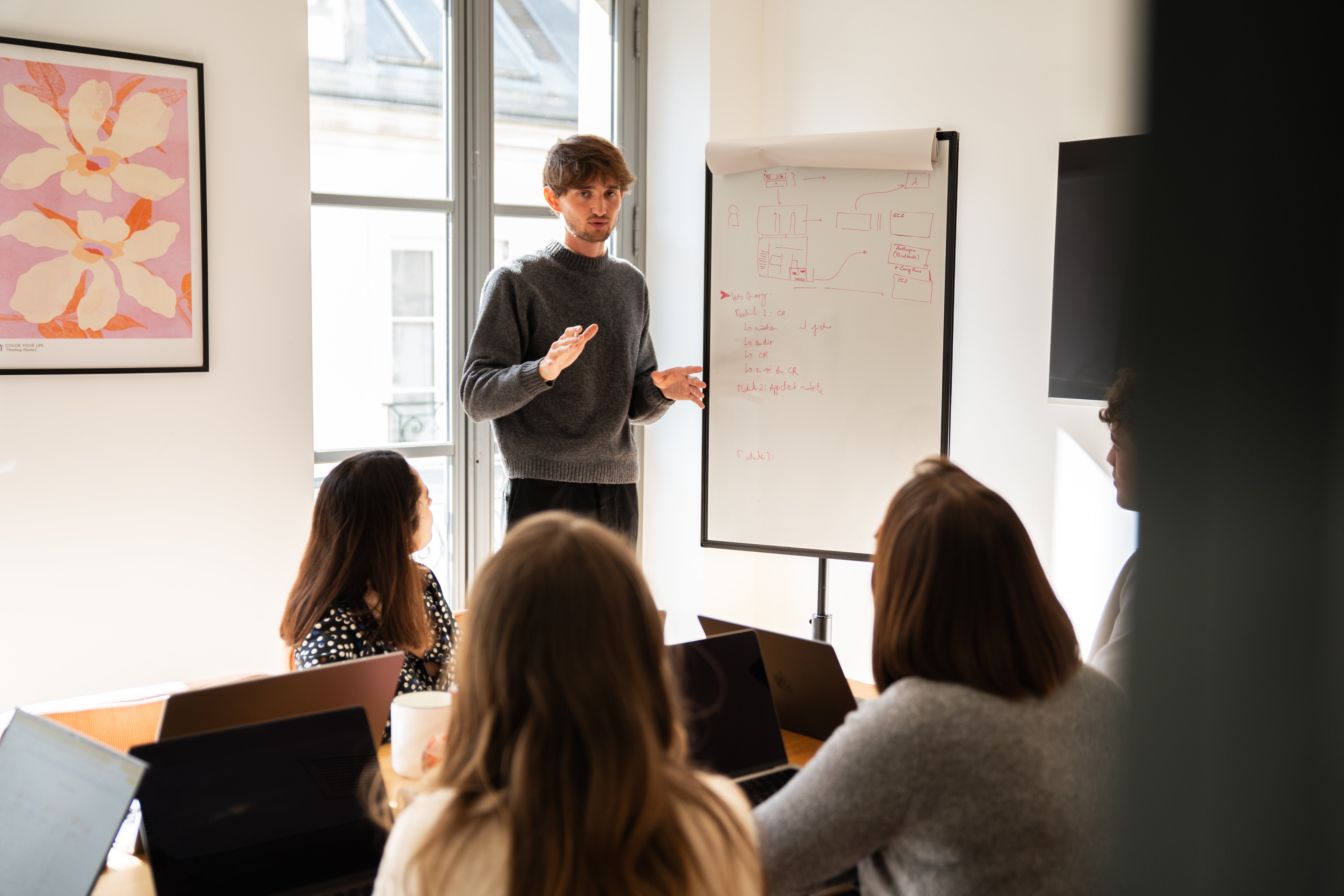 A Galadrim team member presenting a project to a team in a meeting room