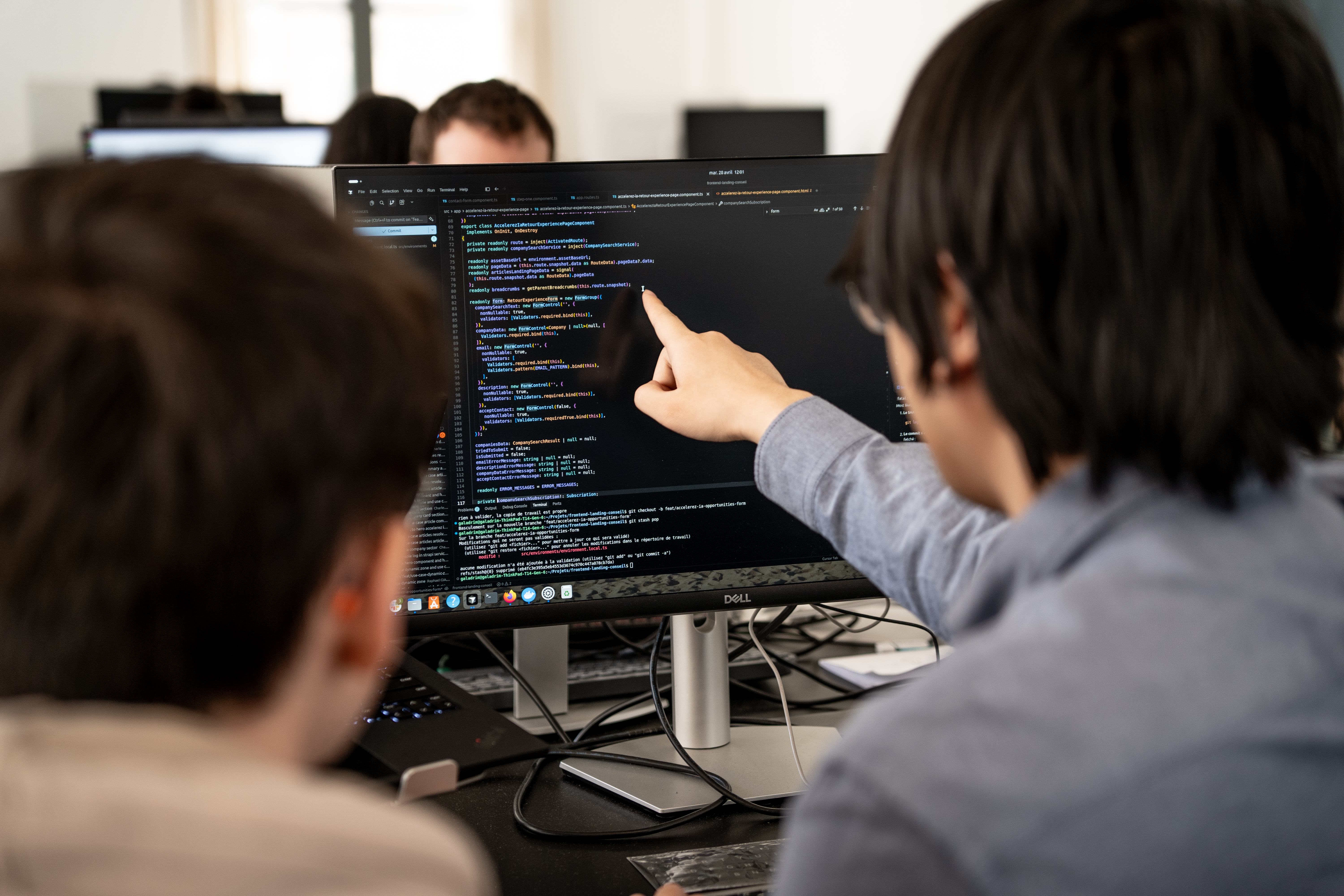 Two Galadrim engineers in front of a screen of code