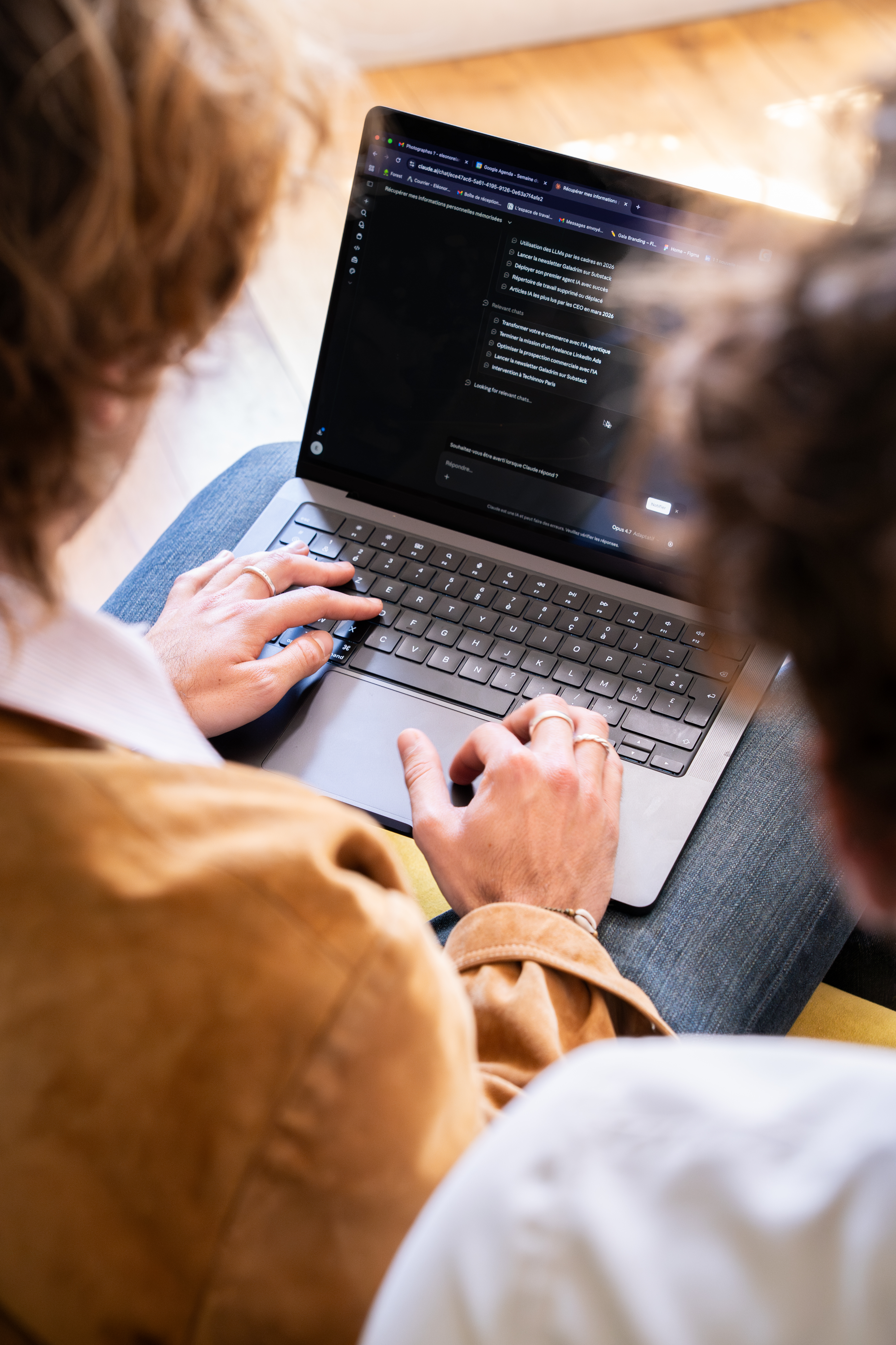 Two people in front of a laptop showing an AI chat interface